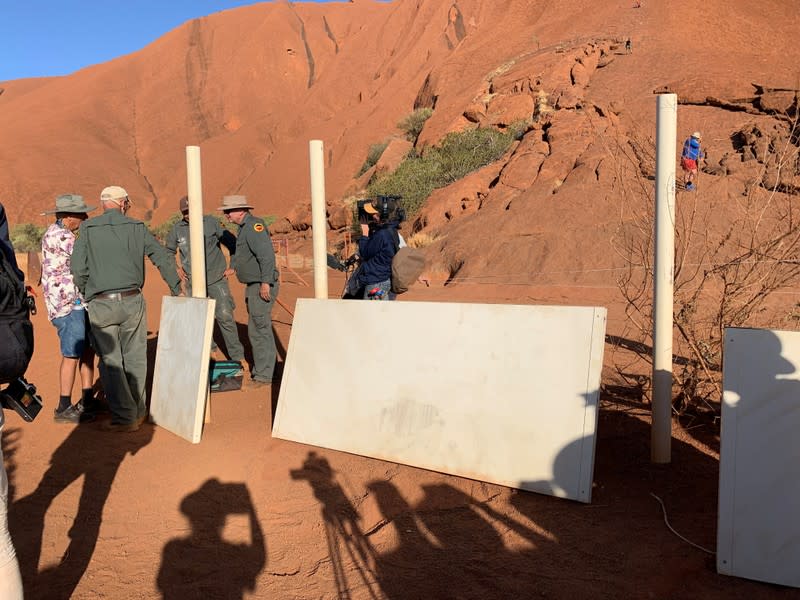 Park rangers at Uluru, formerly known as Ayers Rock, remove the old signs that explain the climb to tourists, near Yulara,