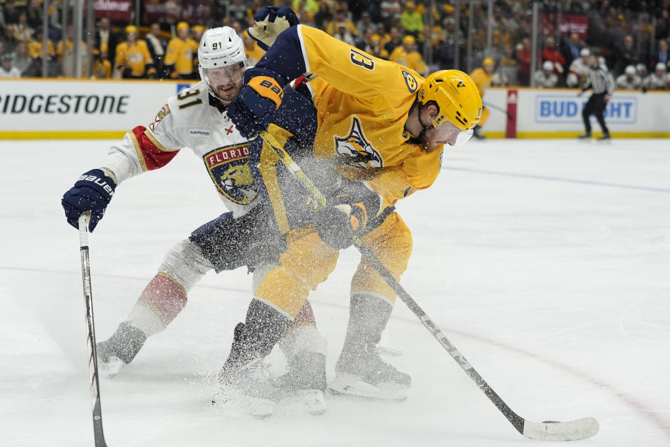 Nashville Predators center Yakov Trenin (13) skates the puck past Florida Panthers defenseman Oliver Ekman-Larsson (91) during the second period of an NHL hockey game Monday, Jan. 22, 2024, in Nashville, Tenn. (AP Photo/George Walker IV)