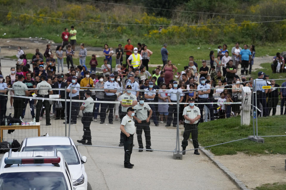 Police patrol fences as Pope Francis meets members of the Roma community at Lunik IX, in Kosice, Slovakia, Tuesday, Sept. 14, 2021, the biggest of about 600 shabby, segregated settlements where the poorest 20% of Slovakia's 400,000 Roma live. Pope Francis traveled to Kosice, in the far east of Slovakia on Tuesday to meet with the country's Roma in a gesture of inclusion for the most socially excluded minority group in Slovakia, who have long suffered discrimination, marginalization and poverty. (AP Photo/Petr David Josek)