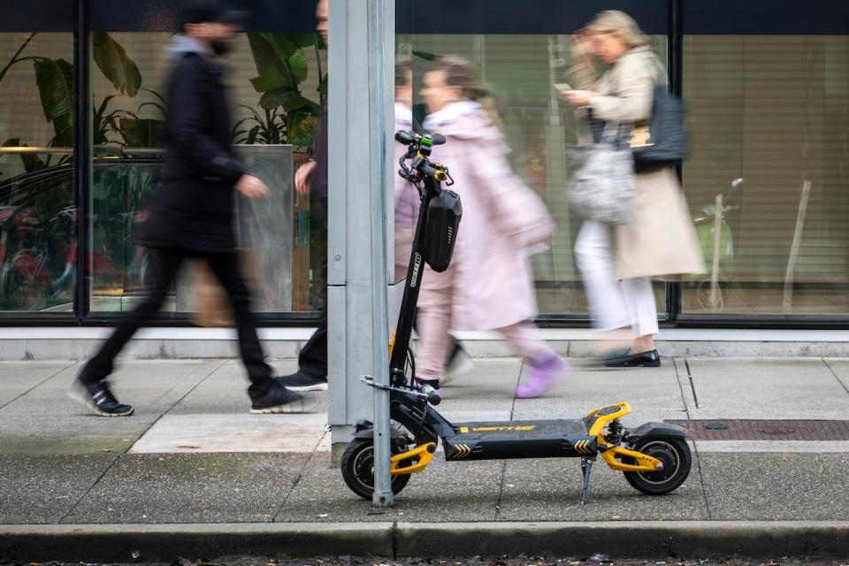 A person rides an electric kick scooter in Vancouver, British Columbia on Thursday, February 22, 2023. 