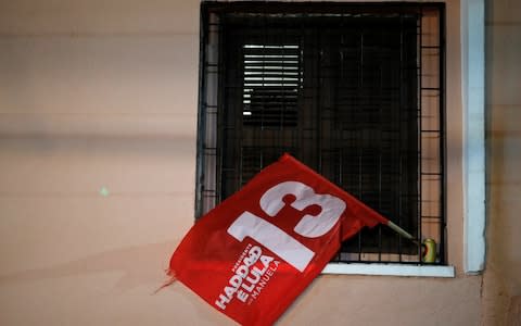 A flag of Fernando Haddad, presidential candidate of Brazil's leftist Worker Party (PT), is seen in a window, in Fortaleza - Credit: Reuters