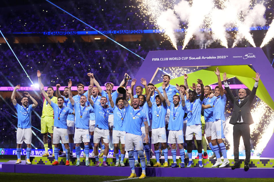 Manchester City's Kyle Walker, center, lifts the trophy at the end of the Soccer Club World Cup final match between Manchester City FC and Fluminense FC at King Abdullah Sports City Stadium in Jeddah, Saudi Arabia, Friday, Dec. 22, 2023. Manchester City won 4-0. (AP Photo/Manu Fernandez)
