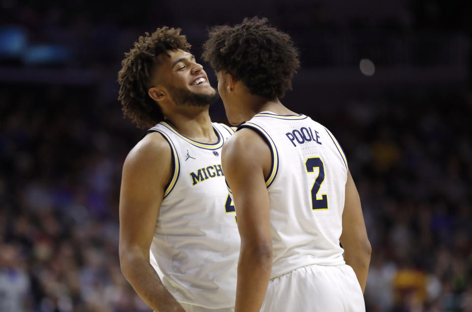 Michigan forward Isaiah Livers, left, celebrates with teammate Jordan Poole after making a basket during a second round men's college basketball game against Florida in the NCAA Tournament, Saturday, March 23, 2019, in Des Moines, Iowa. (AP Photo/Charlie Neibergall)