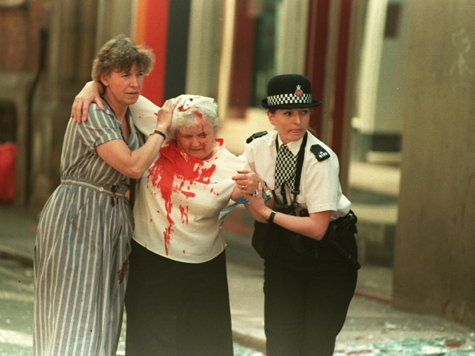 PC Vanessa Winstanley and another woman help a casualty away from the city centre (PA)