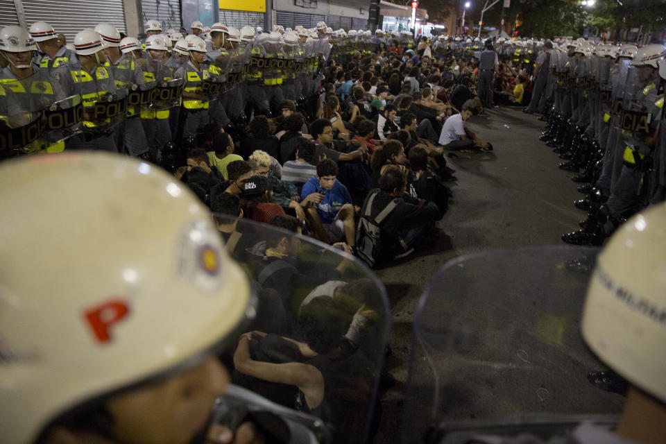 Policemen surround detained demonstrators during a protest against the upcoming World Cup soccer tournament in Sao Paulo, Brazil, Saturday, Feb. 22, 2014. About 1,000 protesters gathered in Brazil's biggest metropolis of Sao Paulo, demonstrating against the billions of dollars being spent to host this year's World Cup while the nation's public services remain in a woeful state.(AP Photo/Andre Penner)