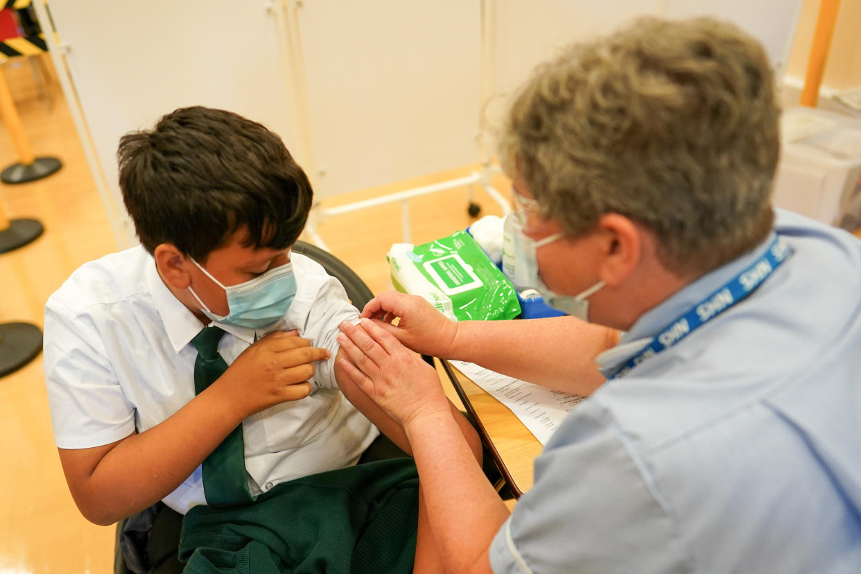 NEWCASTLE UPON TYNE, ENGLAND - SEPTEMBER 22: Felix Dima, 13, from Newcastle receives the Pfizer-BioNTech COVID-19 vaccine at the Excelsior Academy on September 22, 2021 in Newcastle upon Tyne, England.  The Excelsior Academy on Denton Road in Newcastle is the first school in the North East and North Cumbria to offer the Pfizer-BioNTech COVID-19 vaccination to healthy 12-15-year-olds where parents have provided consent. This week the NHS and local School Age Vaccination Services begin immunising children aged 12 to 15 on advice from the UK's four Chief Medical Officers, in a move to reduce the disruption to education caused by COVID-19. The Medicines and Healthcare products Regulatory Agency (MHRA) confirmed that the Pfizer vaccine is safe and effective for 12 to 17-year-olds. (Photo by Ian Forsyth/Getty Images)