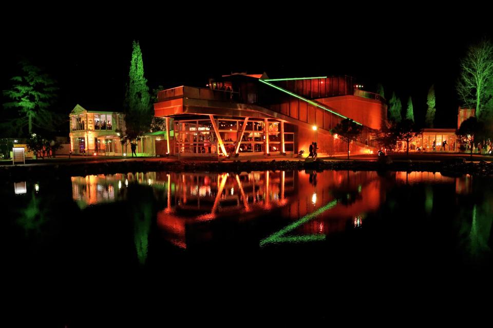 The orange-lit Holland House is reflected in a pond following the appearance of gold medallist Sven Kramer of the Netherlands on stage in front of fans after he set a new Olympic record to win the 5000 meters speedskating race at the 2014 Winter Olympics in Sochi, Russia, Saturday, Feb. 8, 2014. (AP Photo/Matt Dunham)