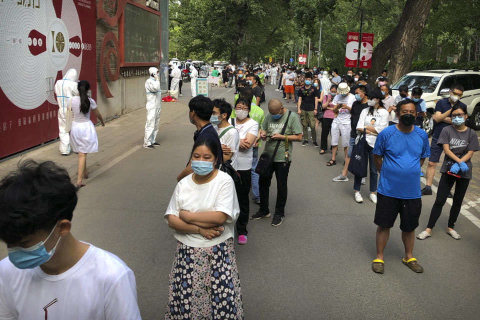 People wait in line at a COVID-19 testing site after they were ordered by the government to be tested after potentially being exposed to the coronavirus outbreak at a wholesale food market in Beijing, Wednesday, June 17, 2020. As the number of cases of COVID-19 in Beijing climbed in recent days following an outbreak linked to a wholesale food market, officials announced they had identified hundreds of thousands of people who needed to be tested for the coronavirus. (AP Photo/Mark Schiefelbein)