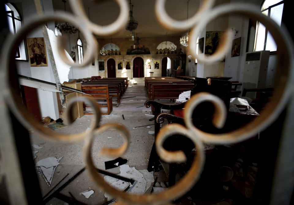 FILE - This February 21, 2013 file photo, the altar of Judeida church is seen damaged by mortar shell, at the Christian village of Judeida, in Idlib province, Syria. The Qatar-based Syrian Network for Human Rights, a Syrian war monitor associated with the opposition said in its report Monday, Sept. 9, 2019, that over 120 Christian places of worship have been damaged or destroyed by all sides in the country’s eight-year conflict. (AP Photo/Hussein Malla, File)