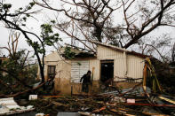 A man looks for valuables in the damaged house of a relative after the area was hit by Hurricane Maria in Guayama, Puerto Rico September 20, 2017. REUTERS/Carlos Garcia Rawlins