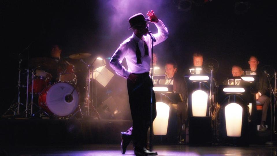 A production still from "Sandy Hackett's Rat Pack Christmas" as the character Sammy Davis, Jr. takes the stage.