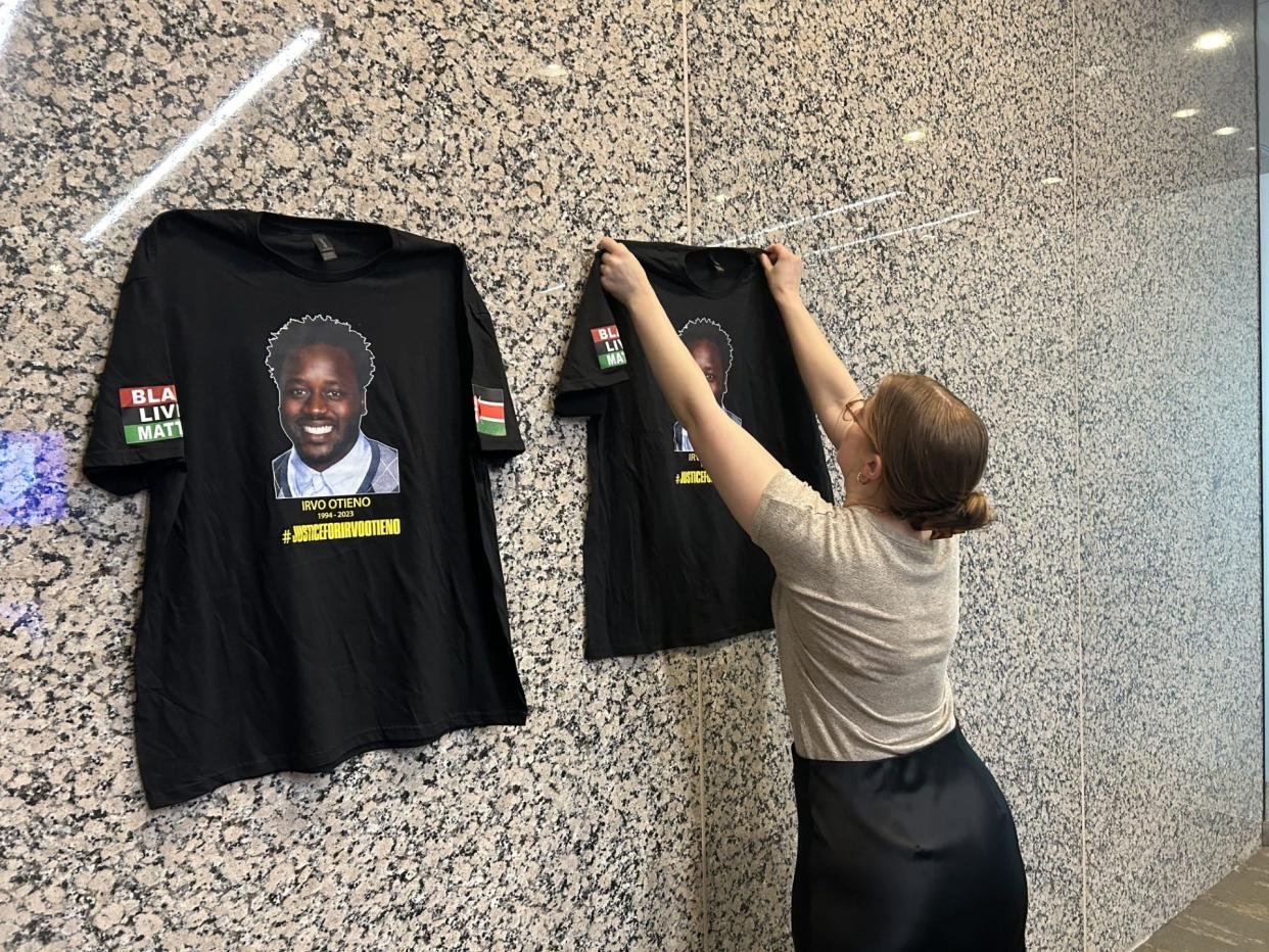 An employee of attorney Mark Krudys puts up T-shirts with the image of Irvo Noel Otieno prior to a news conference Monday, May 6, 2024, in Richmond, Va. Krudys represents the Otieno family. The presser was called to react to news that the Dinwiddie County prosecutor was withdrawing charges against five deputies in Otieno's death at Central State Hospital in Dinwiddie County.