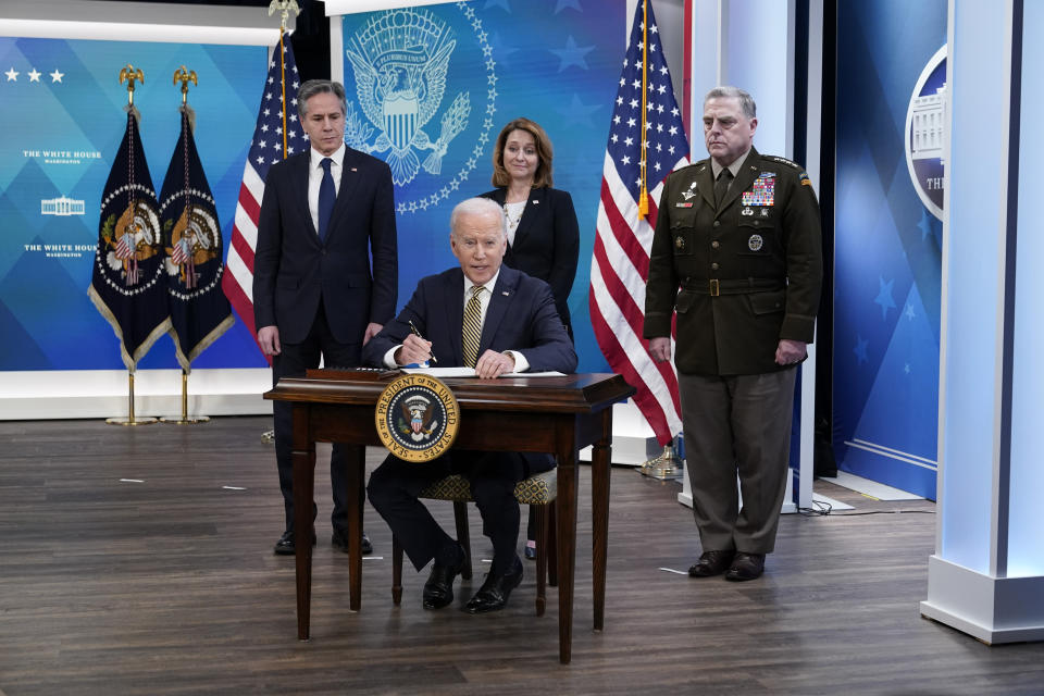 FILE - President Joe Biden signs a delegation of authority in the South Court Auditorium on the White House campus in Washington, March 16, 2022. From left, Secretary of State Antony Blinken, Biden, Deputy Secretary of Defense Kathleen Hicks and Chairman of the Joint Chiefs of Staff General Mark Milley. As the war rages on in Ukraine, the United States is doing more than supporting an ally. It's learning lessons — with an eye toward a possible clash with China. (AP Photo/Patrick Semansky, File)