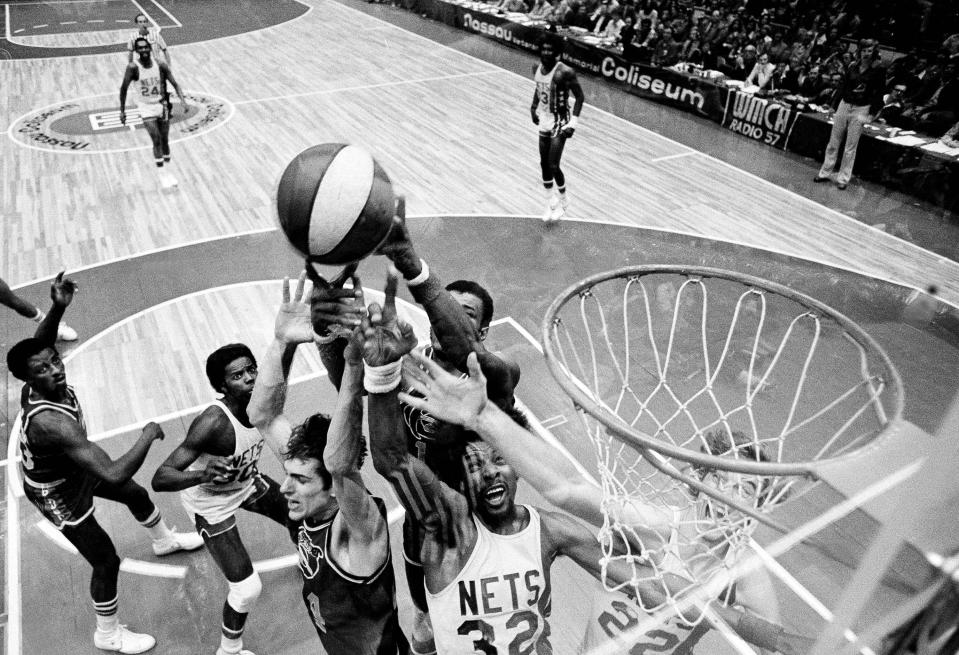 FILE - Denver Nuggets' Bobby Jones, second left, Nets' Julius Erving, fourth left, and New York Nets' Jim Eakins, right, battle for a rebound during the ABA championship playoff game at the Nassau Coliseum in Uniondale, N.Y., on May 14, 1976. The Denver Nuggets are the last of the four ABA teams that merged with the NBA to reach the Finals and is stirring up fond memories of the defunct league. (AP Photo/Richard Drew, File)