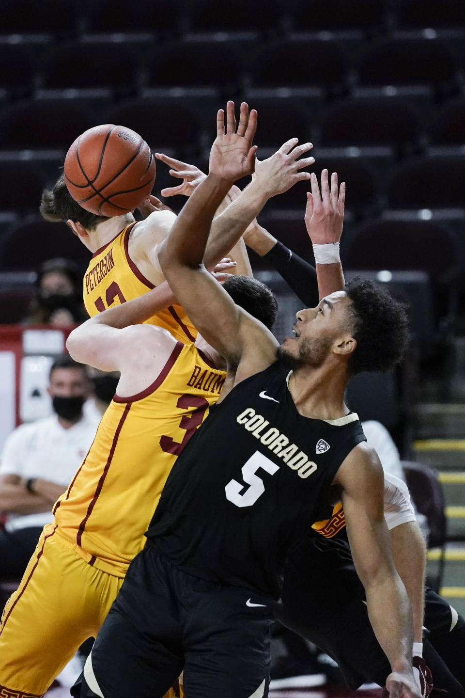 Colorado's D'Shawn Schwartz, front, vies for a rebound with Southern California's Drew Peterson, top left, and Noah Baumann during the first half of an NCAA college basketball game Thursday, Dec. 31, 2020, in Los Angeles. (AP Photo/Jae C. Hong)