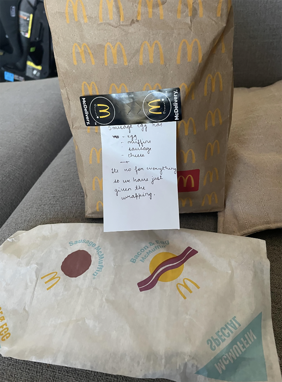 The McDonald's customer's empty wrapper and note about the sausage McMuffin taped to the brown bag. 