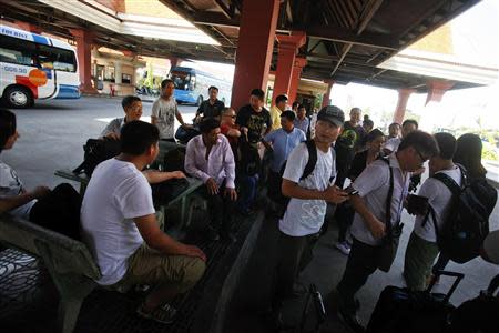 Chinese nationals stand by their belongings after crossing to Cambodia from Vietnam at the Bavet international checkpoint in Svay Rieng province May 15, 2014. REUTERS/Samrang Pring