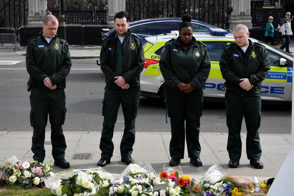 Emergency services workers lay flowers at Parliament Square on the anniversary of the Westminster Bridge attack: Reuters