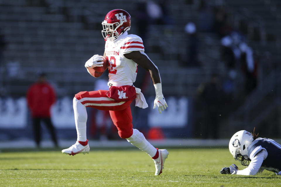 Houston running back Alton McCaskill (22) scores a touchdown as Connecticut defensive back Durante Jones (19) fails to makes a tackle during the first half of an NCAA football game, Saturday, Nov. 27, 2021, in East Hartford, Conn. (AP Photo/Stew Milne)