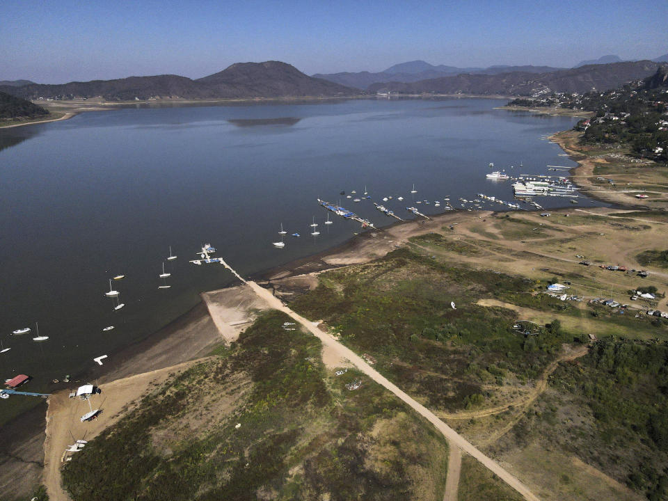 FILE - The banks of the Miguel Aleman dam lie exposed due to low water levels in Valle de Bravo, Mexico, March 14, 2024. According to Mexico's National Water Commission, Valle de Bravo's reservoir has fallen to 29% of its capacity – a historical low -- compared to one year ago when it was at 52%, while the country endures a drought and has imposed restrictions on water taken from the system. (AP Photo/Marco Ugarte, File)