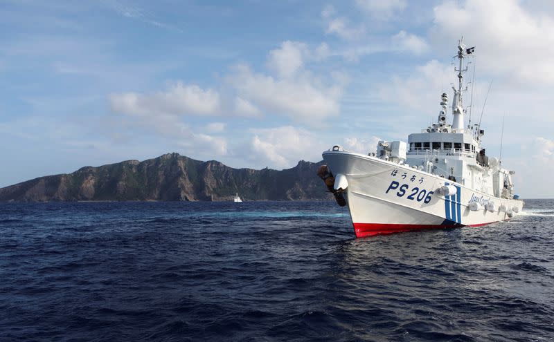 FILE PHOTO: A Japan Coast Guard vessel sails in front of one of the disputed islands in the East China Sea