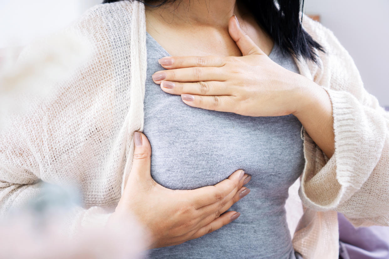 A woman checking her breast.