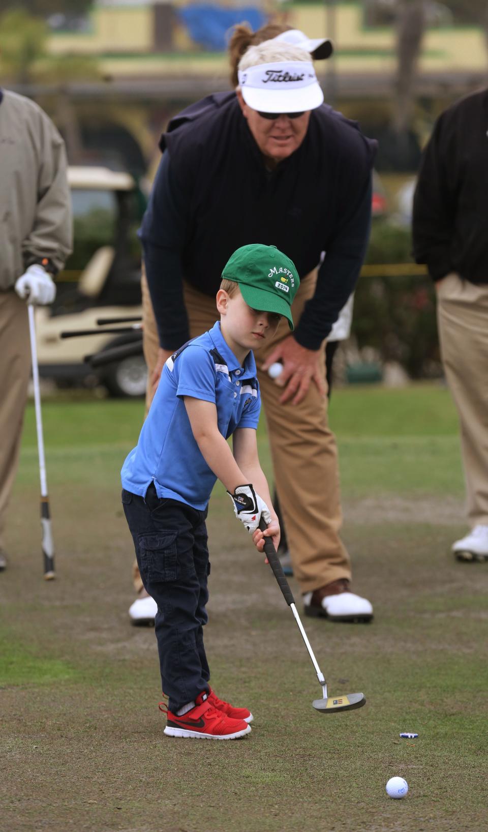 Riley Darby putts under the watch full eye of Andy Bean during the Barkley, Bean, Bryant and Friends Celebrity Skins Game at The First Tee of Lakeland in 2015.