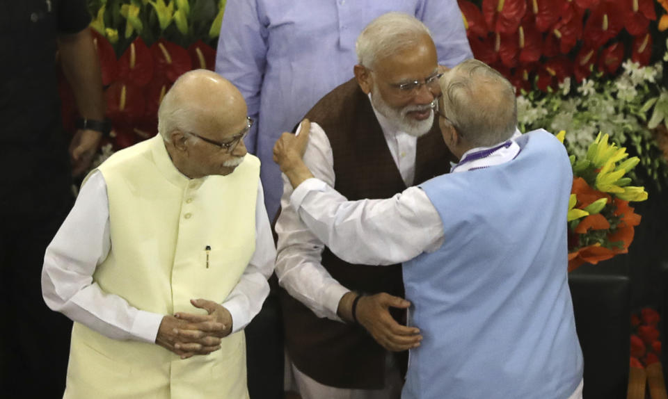 Indian Prime Minister Narendra Modi,second right, hugs senior Bharatiya Janata Party (BJP) leader M.M.Joshi as L.K.Advani, left, watches after being elected ruling alliance leader, in New Delhi, India, Saturday, May 25, 2019. BJP president Amit Shah announced Modi's name as the leader of the National Democratic Alliance in a meeting of the lawmakers in the Central Hall of Parliament in New Delhi, paving the way for Modi's second five-year term as prime minister after a thunderous victory in national elections. (AP Photo/Manish Swarup)