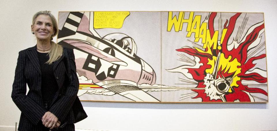 FILE - In this Oct. 9, 2012 file photo, Dorothy Lichtenstein, widow of artist Roy Lichtenstein, poses beside her husband's artwork, a 1963 oil and magna on canvas entitled; Whaam! during the press preview of his first major exhibition since his death, at the National Gallery of Art in Washington. (AP Photo/Manuel Balce Ceneta, File)