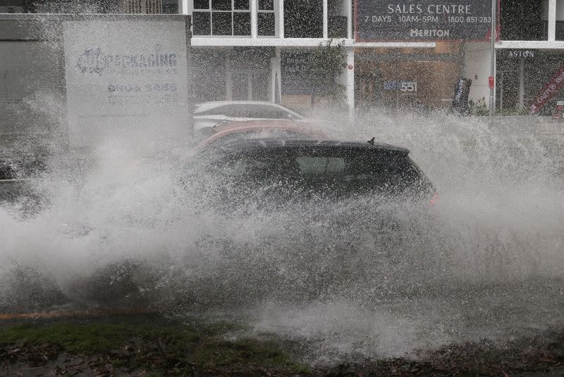 FILE PHOTO: Vehicles drive through floodwaters as heavy rains affect Sydney, Australia