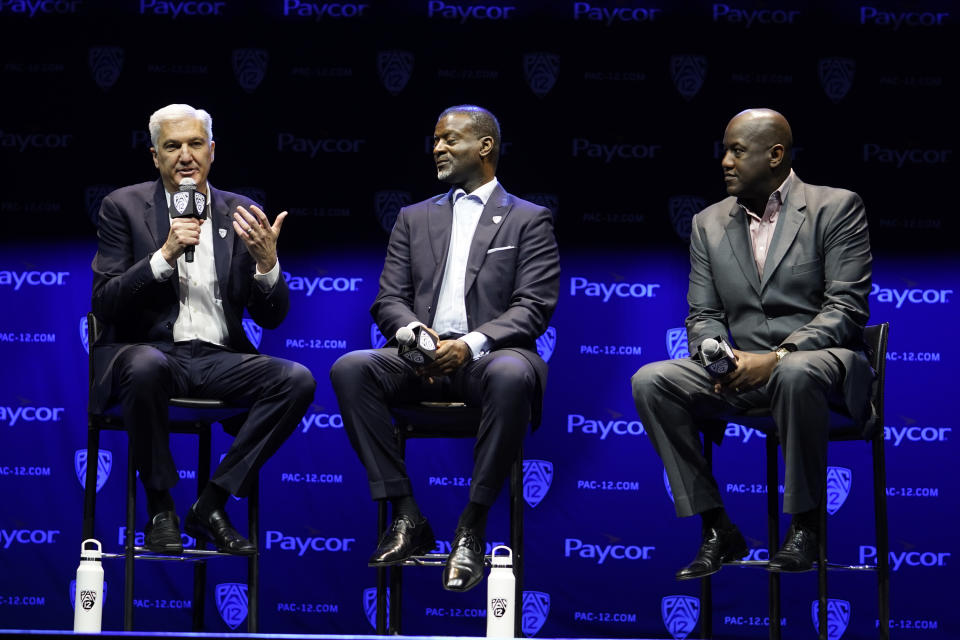 George Kliavkoff, Commissioner of the Pac-12 Conference, left, with Senior Associate Commissioner Merton Hanks, center, and Stanford Athletic Director Bernard Muir take questions from the media during opening of the Pac-12 NCAA college football media day Friday, July 29, 2022, in Los Angeles. (AP Photo/Damian Dovarganes)