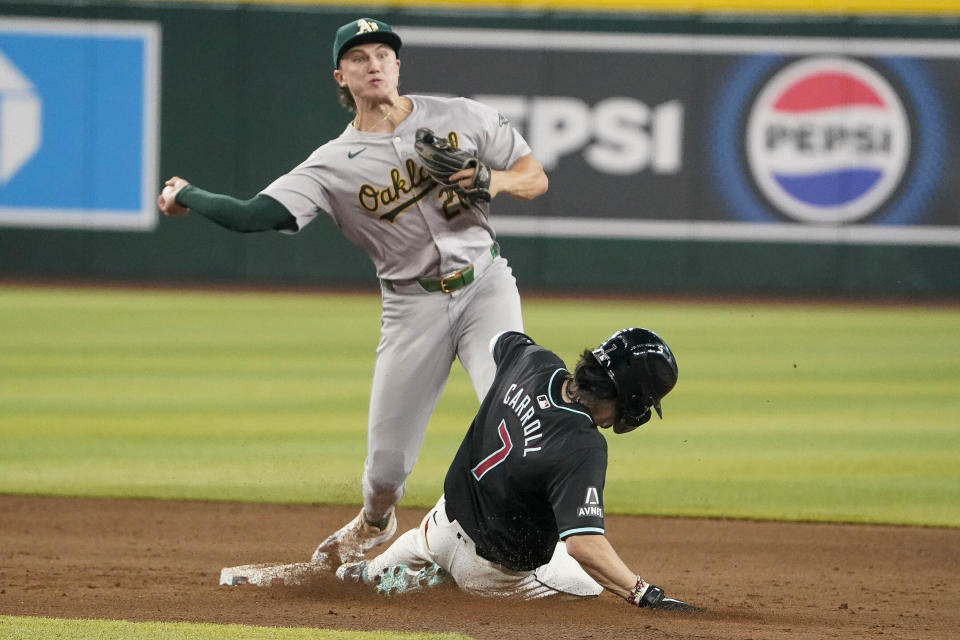 Oakland Athletics' Zack Gelof (20) gets the out on Arizona Diamondbacks' Corbin Carroll to start a double play during the eighth inning of a baseball game, Sunday, June 30, 2024, in Phoenix. (AP Photo/Darryl Webb)