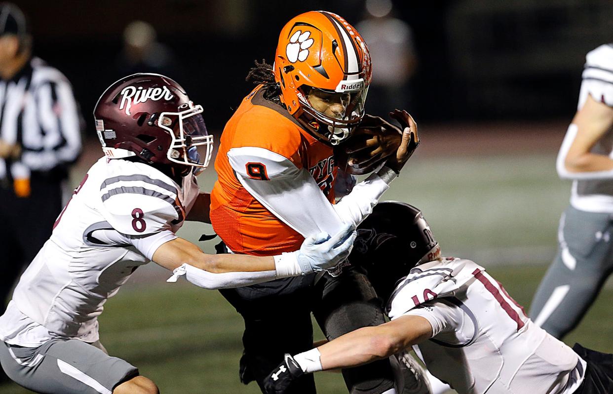 Mansfield Senior High School's Duke Reese (9) is tackled by Rocky River High School's Josh Mommers (10) and Cameron Bulkowski (8) during their OHSAA Division III high Region 10 high school football quarterfinal game action Friday, Nov. 3, 2023 at Rocky River Stadium. TOM E. PUSKAR/MANSFIELD NEWS JOURNAL