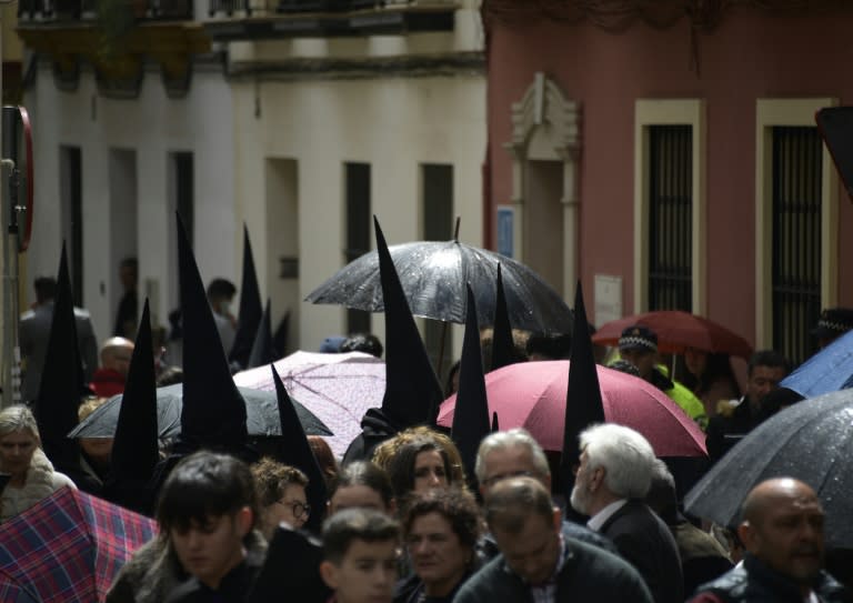 Penitentes y público en el barrio de San Bernardo, en Sevilla, tras la anulación de una procesión debido a la lluvia, el 27 de marzo de 2024 (CRISTINA QUICLER)