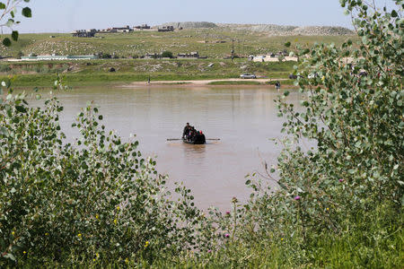 Displaced Iraqis from Mosul cross the Tigris by boat as flooding after days of rainfall has closed the city's bridges, at the village of Thibaniya, south of Mosul. REUTERS/Muhammad Hamed