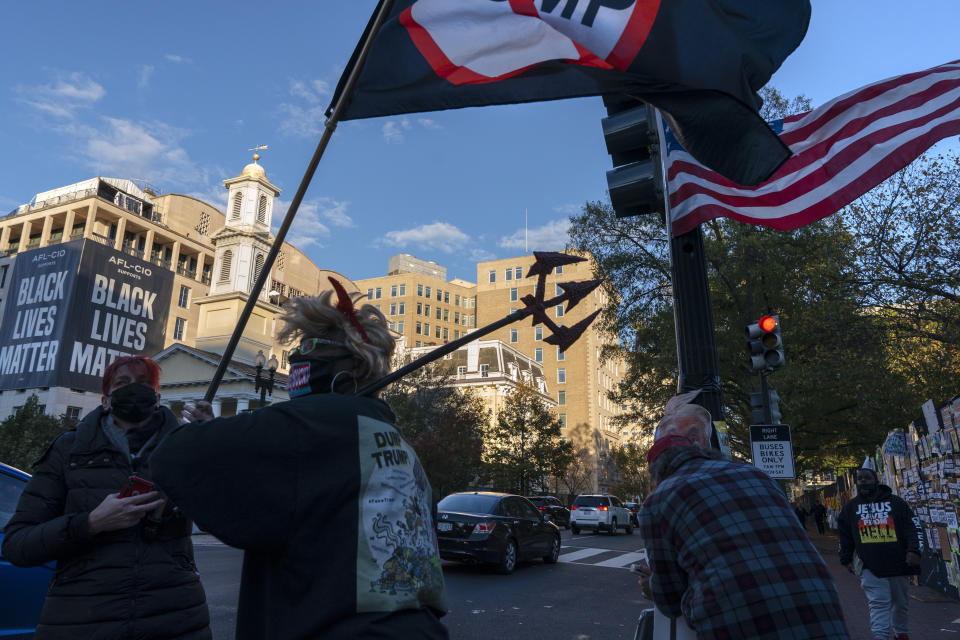 Nadine Seiler, of Waldorf, Md., center, wears a "devil Trump" costume while protesting against President Donald Trump, Friday, Oct. 30, 2020, on the section of 16th Street renamed Black Lives Matter Plaza, near the White House in Washington. (AP Photo/Jacquelyn Martin)