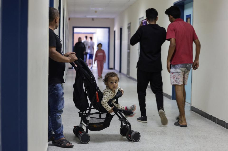 2023年10月20日，黎巴嫩南部城市泰爾（Tyre）一所學校，現在充作收容南部逃難居民的設施，來自阿塔隆村（Aitaroun）的哈珊（Mohammed Hassan）推著座嬰兒車的女兒在走廊上。路透社