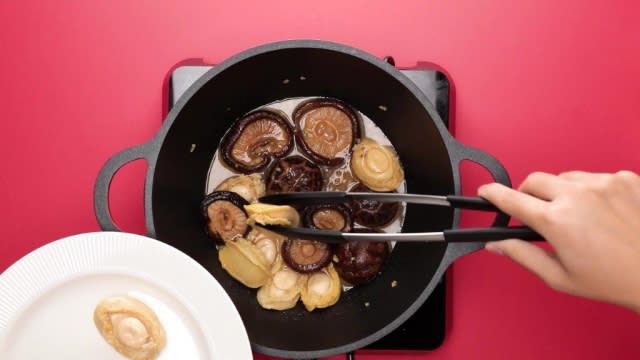 Removing abalones from pot with tongs