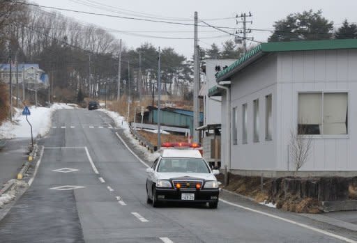 A police vehicle patrols the deserted streets of Iitate, Fukushima Prefecture. Some 6,000 residents were forced to flee Iitate after radioactive dust from the crippled Fukushima Daiichi nuclear plant fell on this once idyllic farming village, leaving behind houses and shops that were once the focus of village life