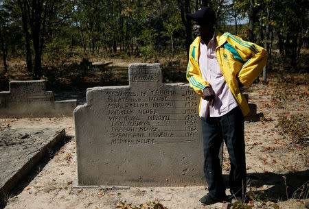 Pastor John Moyo, 76, stands amongst graves of people killed during a government crackdown on rebels loyal to Robert Mugabe's political rival Joshua Nkomo in the mid-1980s, site near Tsholotsho, Zimbabwe, June 23, 2018. Picture taken June 23, 2018. REUTERS/Philimon Bulawayo