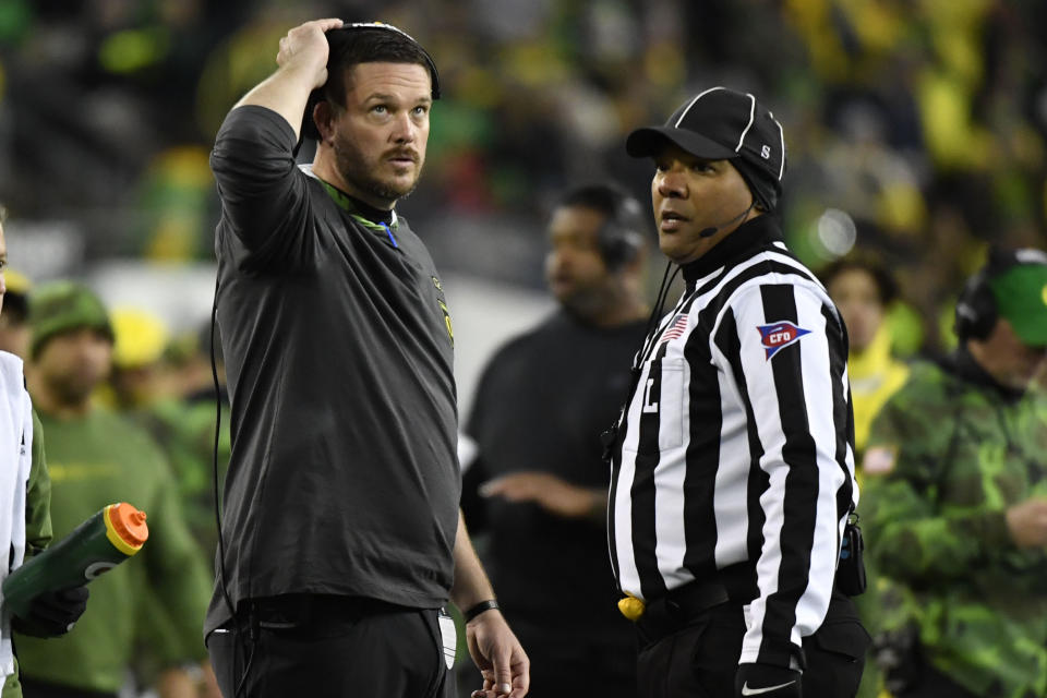 Oregon head coach Dan Lanning, left, looks up at the scoreboard during review during the first half of an NCAA college football game against Washington, Saturday, Nov. 12, 2022, in Eugene, Ore. (AP Photo/Andy Nelson)