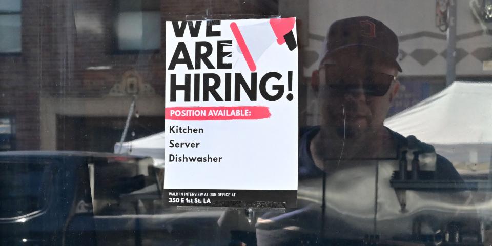 A "We Are Hiring" sign on a window.