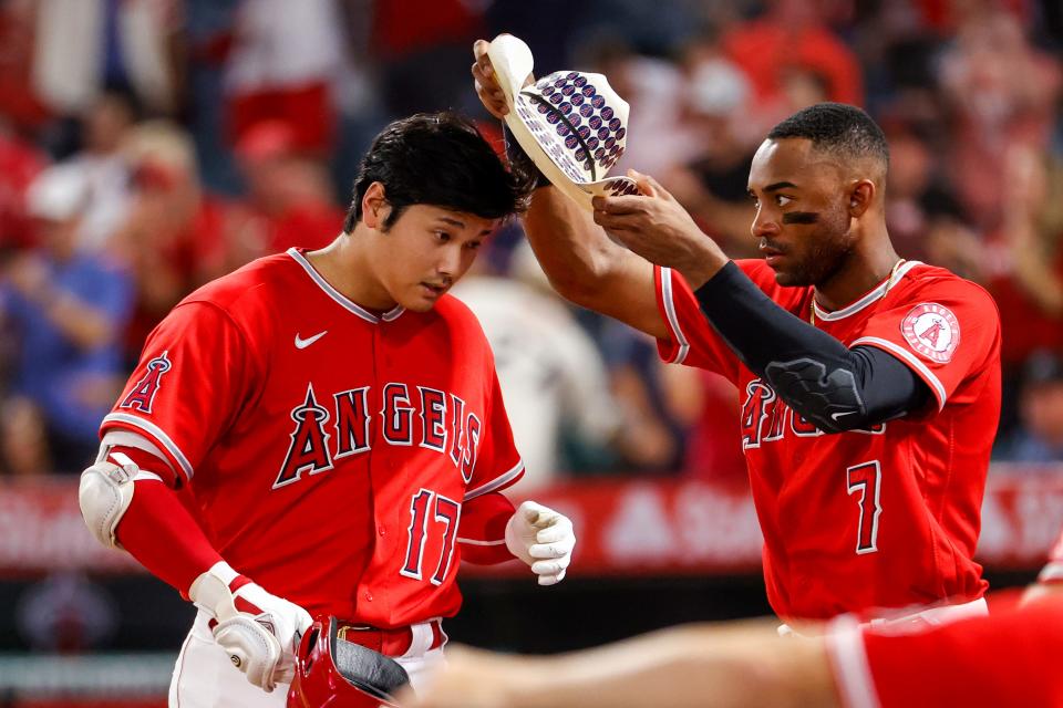 Angels left fielder Jo Adell puts a cowboy hat onto designated hitter Shohei Ohtani while celebrating Ohtani's two-run home run during the third inning on Monday, Sept. 5, 2022, in Anaheim, California.