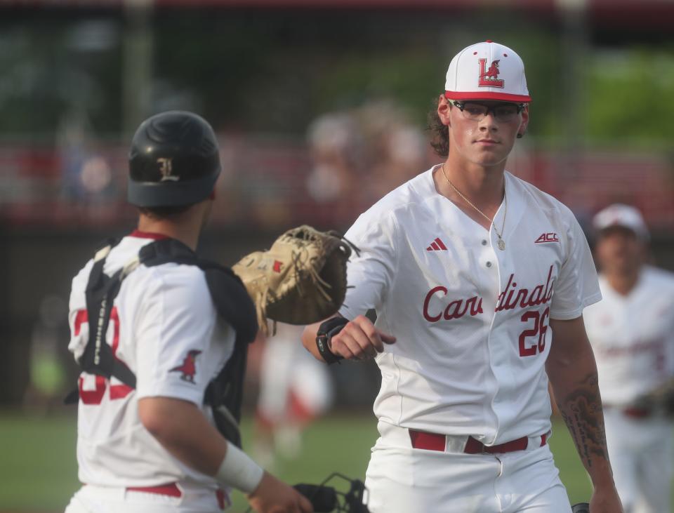 Louisville’s Greg Farone gets a fist bump from catcher Jack Payton after the inning against Florida State.May 19, 2023