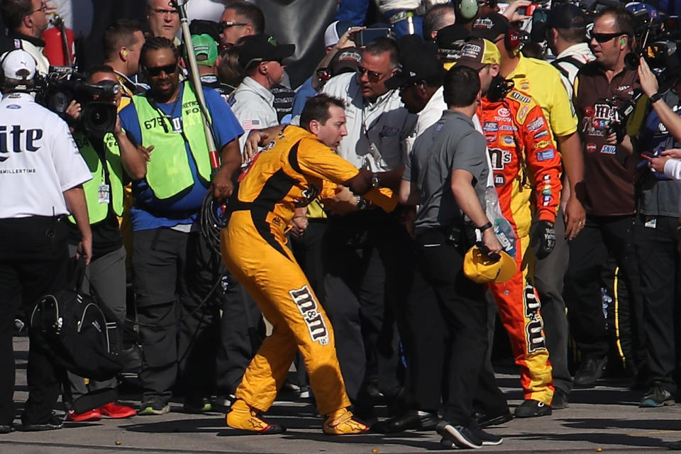 LAS VEGAS, NV – MARCH 12: Kyle Busch, driver of the #18 M&M’s Toyota, is escorted away by a NASCAR official after an incident on pit road with Joey Logano (not pictured), driver of the #22 Pennzoil Ford, following the Monster Energy NASCAR Cup Series Kobalt 400 at Las Vegas Motor Speedway on March 12, 2017 in Las Vegas, Nevada. Busch and Logano made contact on the track during the last lap of the race leading to the incident on pit road. (Photo by Chris Graythen/Getty Images)