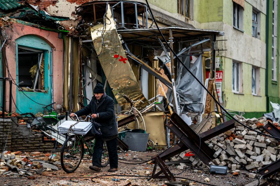 A  local resident pushes his bicycle past ‘hedgehog' tank traps and rubble, down a street in Bakhmut, Donetsk region, on 6 January 2023, amid the Russian invasion of Ukraine (AFP via Getty Images)