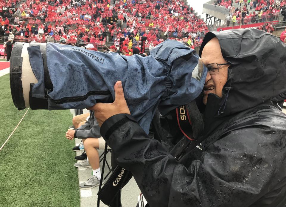 Columbus Dispatch editorial photographer Fred Squillante shoots an Ohio State football game in the rain on Saturday, September 8, 2018.