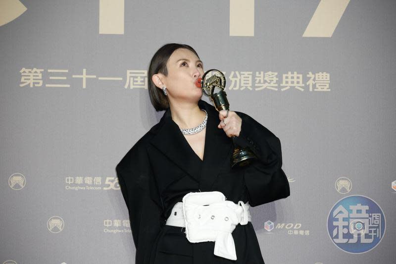 獲得最佳國語女歌手獎的魏如萱，在後台開心親吻獎座。