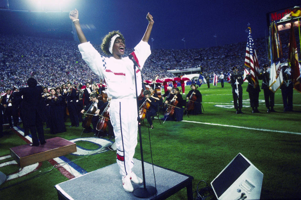 Whitney Houston sings the National Anthem during the pregame show at Super Bowl XXV while tens of thousands of football fans wave tiny American flags in an incredible outburst of patriotism during the Persian Gulf War on Jan. 27, 1991.&nbsp;