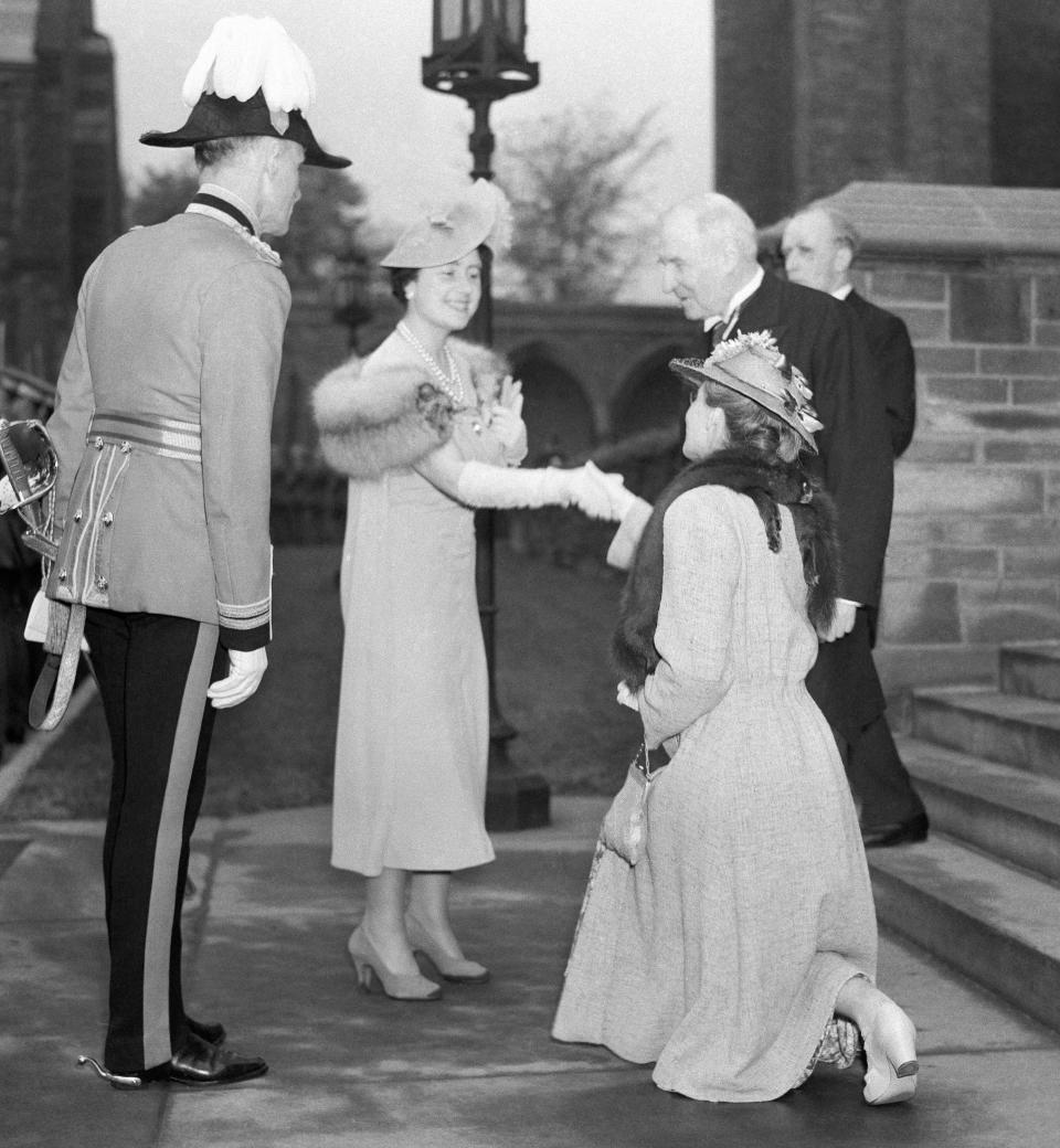 A woman curtsies to Queen Elizabeth the Queen Mother in 1939.
